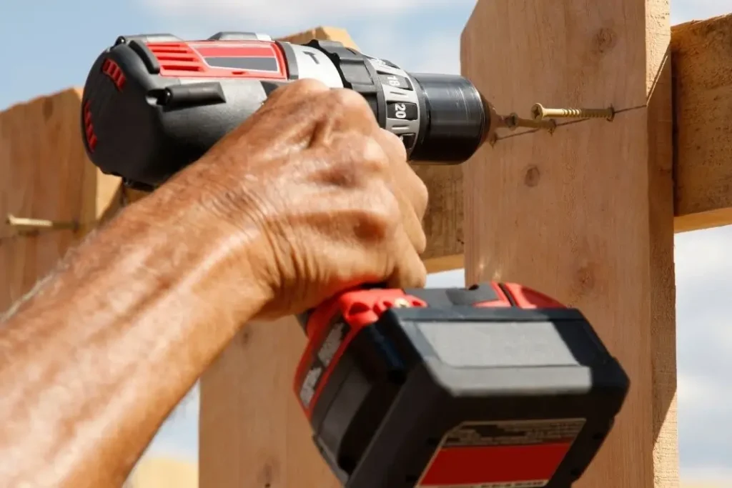contractor screwing nails on a fence